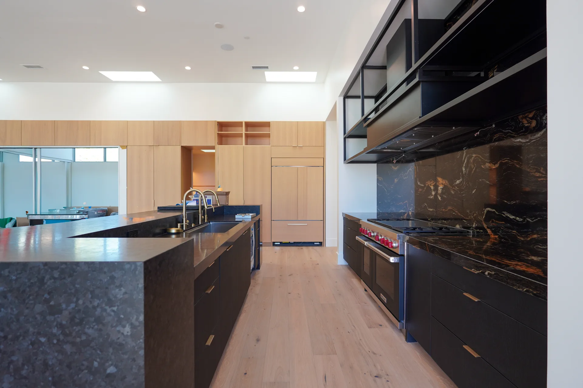 Kitchen with black steel shelving, stone backsplash and island