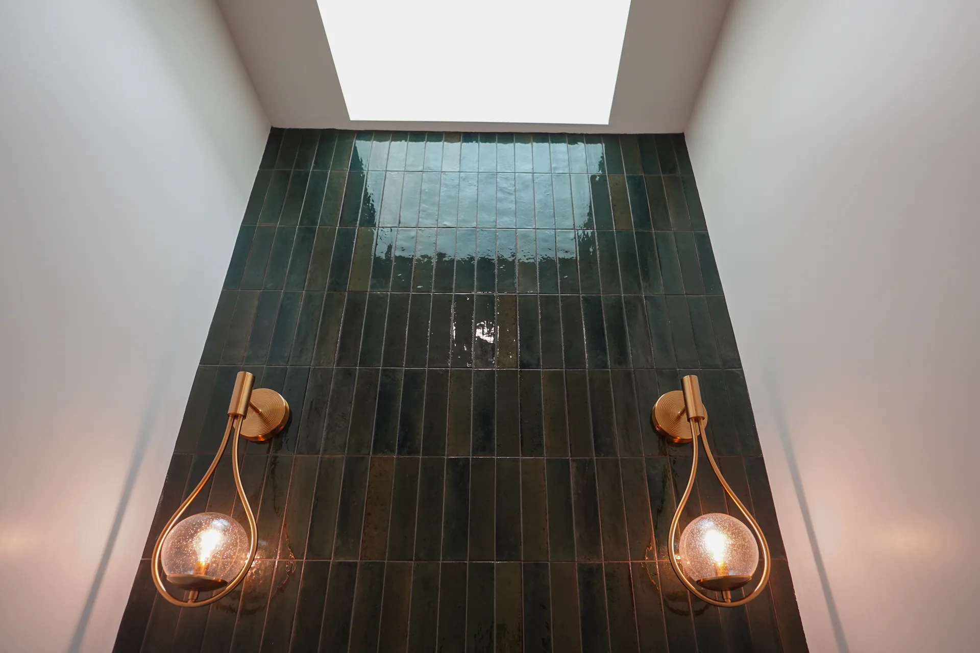 Skylight above the green tile wall in the powder room