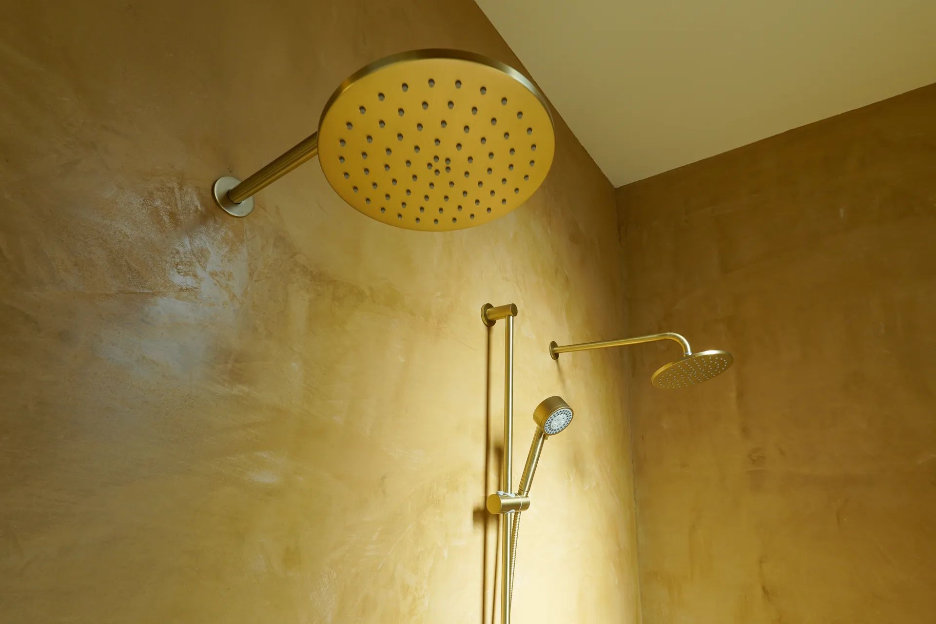 Brass rain shower head and hand shower in the primary bath
