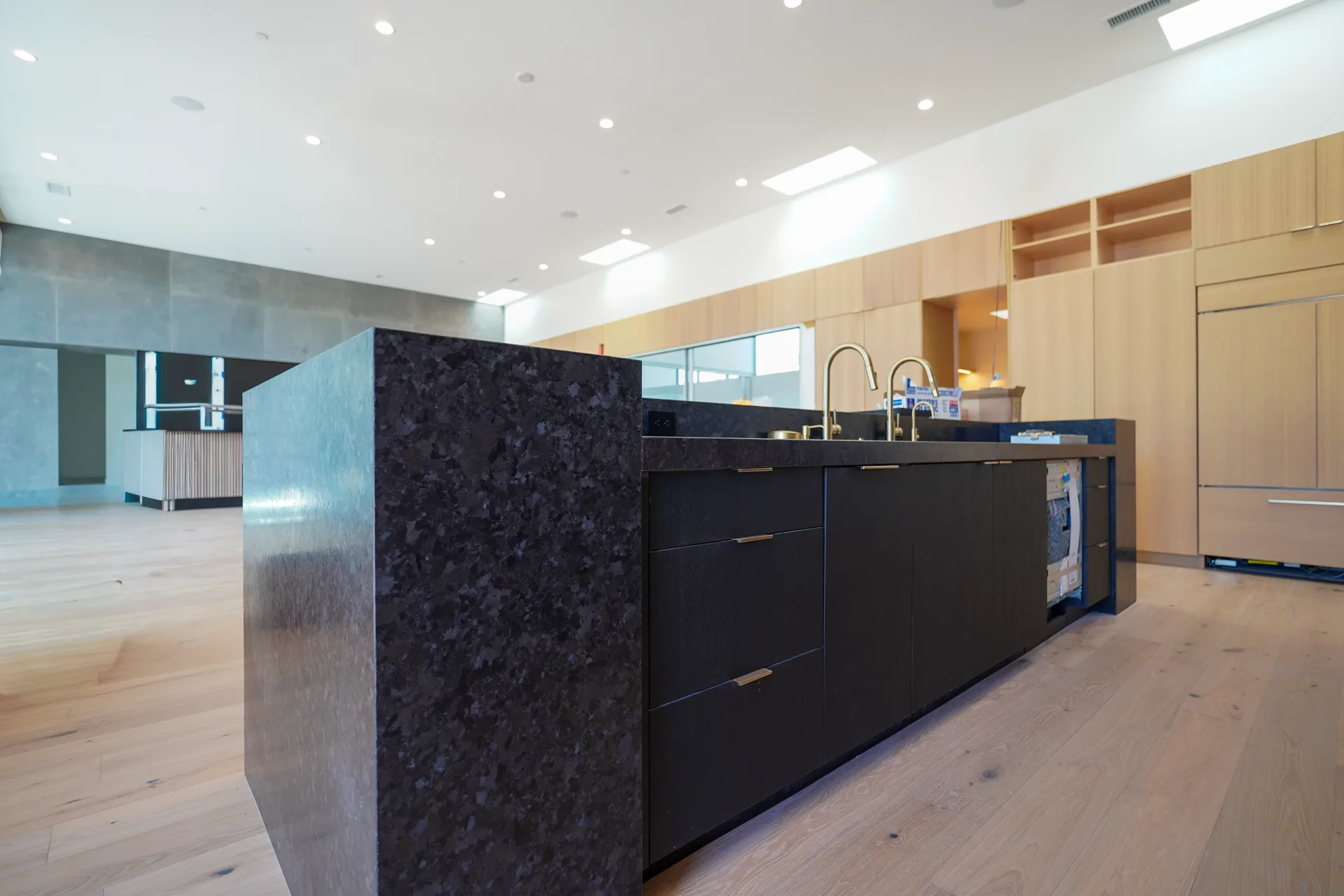 Kitchen island with waterfall stone edge and white oak cabinetry
