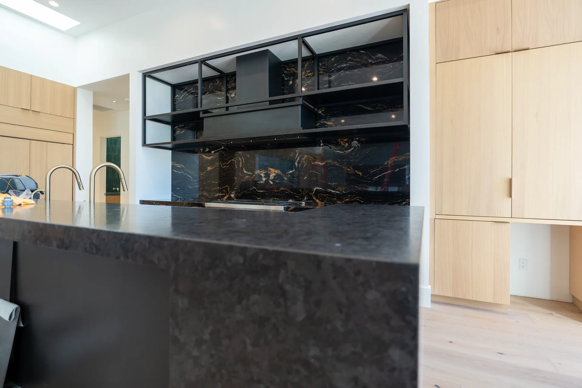 Waterfall island corner in leathered dark granite
