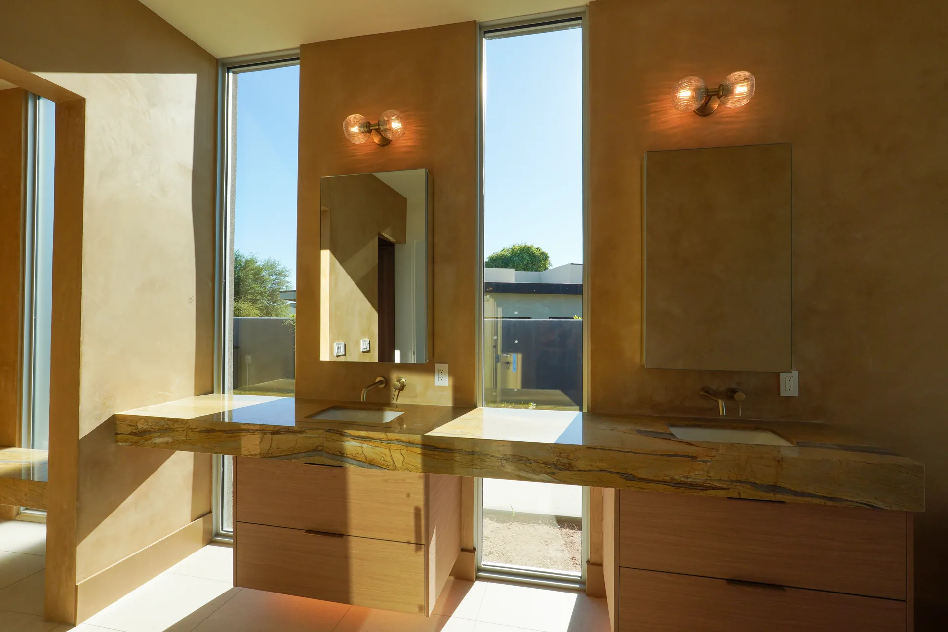 Primary bath with double vanities and floor-to-ceiling glass