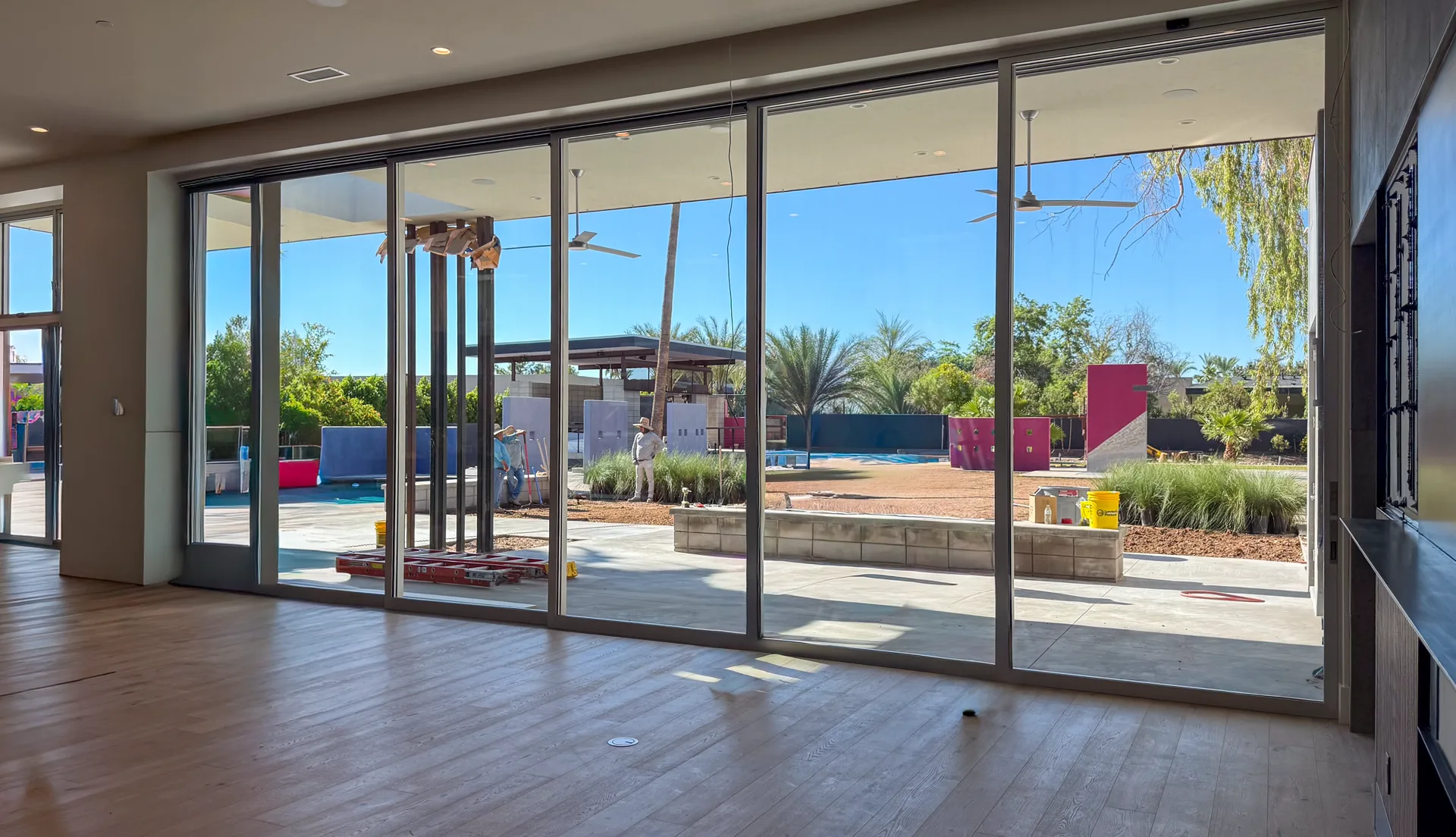 Family room view through glass walls to the pool and yard